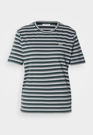 Zaļi un balti svītrains T-krekls, kas izgatavots no mīksta kokvilnas. Apaļa apkakle ar kontrastējošu apdari. Mazs Lacoste logo kreisajā krūtīs.