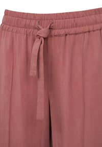 Luftige, staubrosa Hosen mit elastischem Bund, vorderer Bindeschleife und weicher Textur. Verfügt über flache Falten für ein zusätzliches Design.