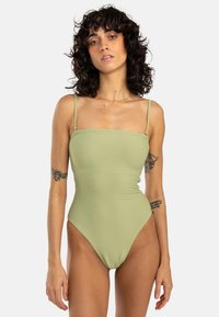 Maillot de bain une pièce en tissu côtelé vert clair, avec de fines bretelles réglables, un décolleté carré et une coupe de jambe haute.