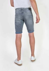 Grijze denimshorts met opgerolde zomen, vijf-pocket ontwerp en een gladde textuur, met een zwart taillebandlabel en contrasterende hardware.
