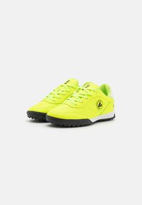 Scarpe da ginnastica giallo neon con tomaia sintetica testurizzata, suola in gomma nera e dettagli bianchi. Presentano un logo sul lato e un design con lacci.