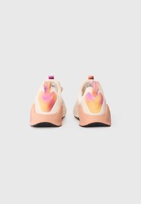 La scarpa presenta una toma leggera di colore crema, dettagli sul tallone in gradiente rosa e arancione, e una suola in gomma testurizzata per una migliore aderenza.