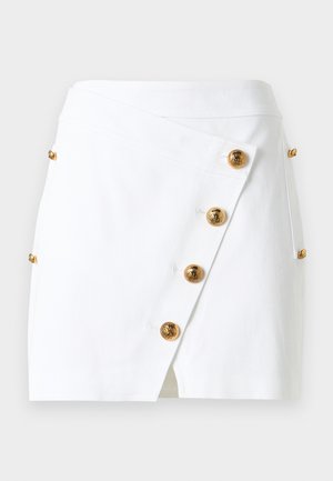 Bijela preklopna suknja od pamuka, sadrži zlatne okrugle gumbe duž prednjeg dijela i bočni prorez za dodatni detalj. Glatka tekstura, uski kroj.