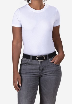 Personne portant un t-shirt blanc uni à manches courtes, rentré dans un jean gris avec une ceinture noire et une boucle argentée.