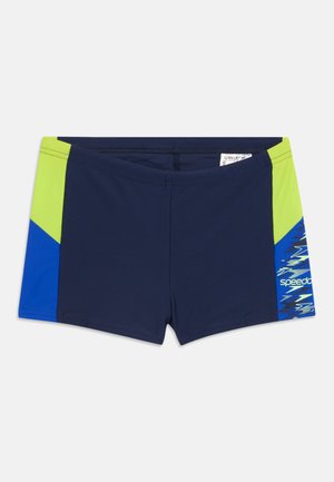Costume da bagno blu navy con pannelli laterali verde lime e blu, con logo Speedo sulla gamba destra.