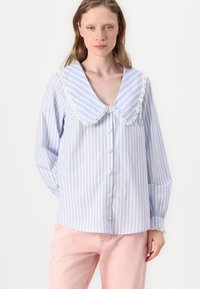 Camicia a righe blu chiaro e bianco con un ampio colletto arrotondato con rifiniture in pizzo, chiusura a bottoni frontale e maniche lunghe con polsini bottonati.