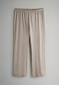 Beżowe, szerokie spodnie wykonane z miękkiego, lekkiego materiału z elastycznym pasem. Gładka tekstura i brak dodatkowych zdobień.
