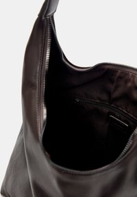 Brown leather tote bag with a smooth texture, featuring a zipper closure at the top and a small inner pocket for organization.