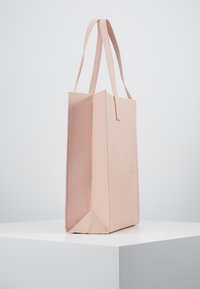 Roze totebag met een gestructureerd ontwerp, gemaakt van textuurmateriaal. Beschikt over lange handvatten en een geperst logo aan de voorkant.