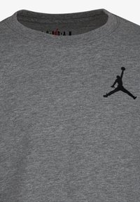 Grijze katoenen sweatshirt met een ronde hals en zwart geborduurd Air Jordan-logo op de borst. Textuurstof met een lichte heathering.
