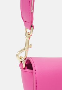 Rosa läderhandväska med en slät yta, som har en klämma i guldfärgad metall och sömnadsdetaljer längs kanterna.