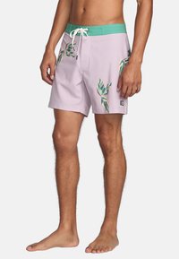 Lichtpaarse zwemshorts met een groene elastische tailleband, voorzien van tropische bladerenprints in groene en beige tinten, en een voorzak.