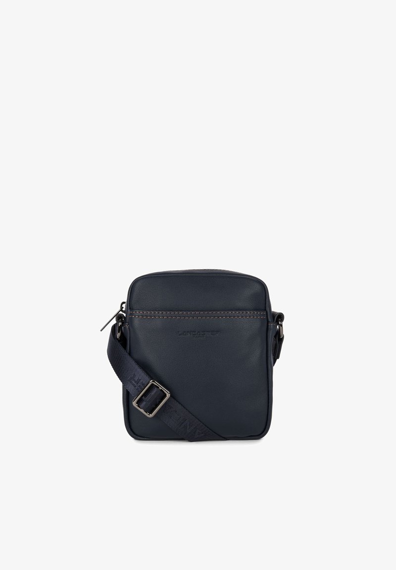 Borsa a tracolla in pelle blu navy con design piatto, chiusura a zip e tracolla regolabile. Presenta cuciture marroni e un logo sul davanti.