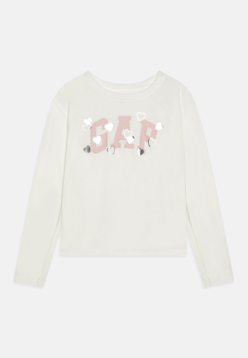 Λευκό πουκάμισο με μακριά μανίκια, featuring το ροζ λογότυπο "GAP" διακοσμημένο με ασημένιες και λευκές καρδιές μπροστά. Μαλακό βαμβακερό υλικό.