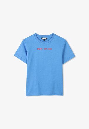 Camiseta de algodón azul con cuello redondo. Presenta texto rojo que dice "DKNY EST. 1989" en el frontal. Tiene mangas cortas y dobladillo recto.