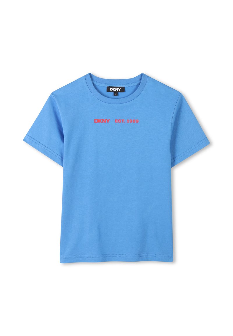 Camiseta de algodón azul con cuello redondo. Presenta texto rojo que dice "DKNY EST. 1989" en el frontal. Tiene mangas cortas y dobladillo recto.