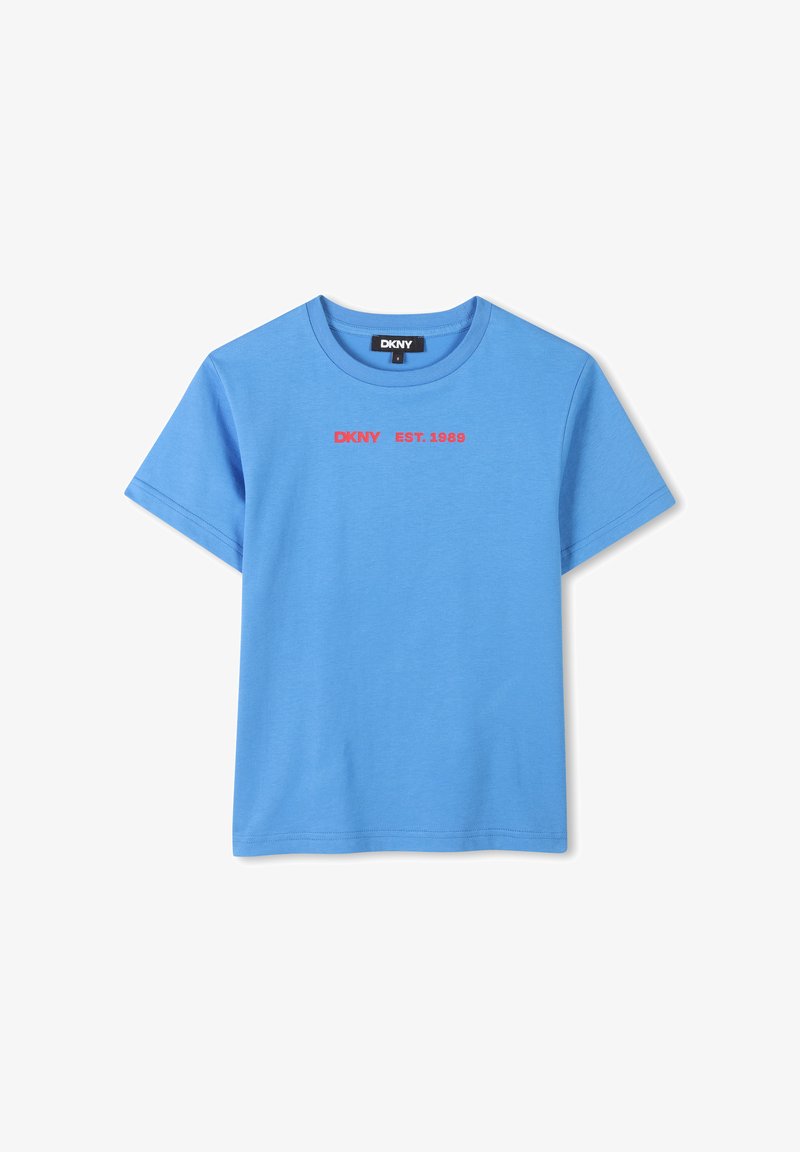 Camiseta de algodón azul con cuello redondo. Presenta texto rojo que dice "DKNY EST. 1989" en el frontal. Tiene mangas cortas y dobladillo recto.