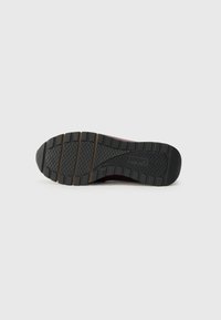 Black rubber outsole with textured tread pattern, featuring multiple grooves and ridges for improved grip and traction.