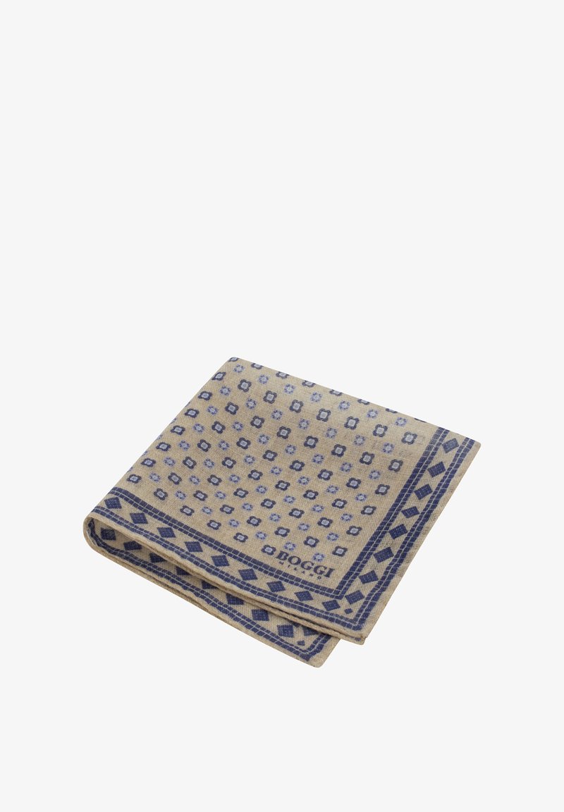 Šviesiai ruda vilnos antklodė su mėlynu geometriniu raštu, kuriame yra deimantų ir gėlių akcentų, sulankstyta su matomu logotipu apatinėje kampe.