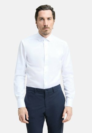 Witte button-up shirt met lange mouwen, een klassieke kraag en een soepele textuur, gecombineerd met donkerblauwe pantalon.