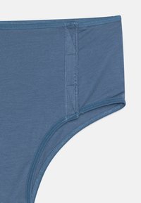Slip in tessuto blu, morbido e con una texture liscia. Presenta bordi cuciti e una vita senza cuciture per un comfort ottimale.