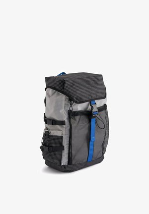 Mochila gris y negra con patrón de cuadrícula, bolsillos laterales de malla, acentos de herrajes azules, correas ajustables y cierre superior plegable.