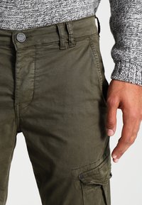 Olijf groene cargobroek van katoen, met een klassieke pasvorm, zijzakken met kleppen en een knoopsluiting bij de taille.