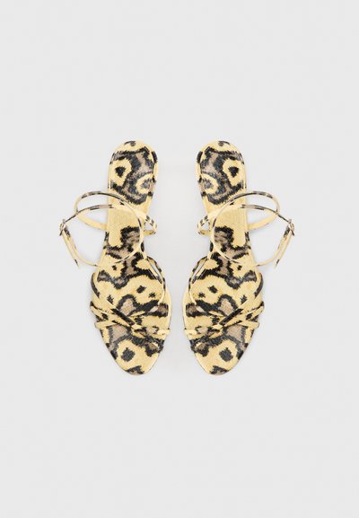 Φλατ σανδάλια με λεοπάρ μοτίβο και λεπτές λουριά. Χρωματικός συνδυασμός κίτρινου, μαύρου και καφέ. Λεία υφή και ανοιχτό στυλ με δάχτυλα.