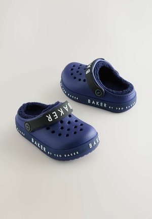 Tumši zili koka ar mīkstu iekšējo oderi, ar ventilācijas caurumiem un melnu siksnu, uz kuras ir zīmola nosaukums "BAKER by TED BAKER."