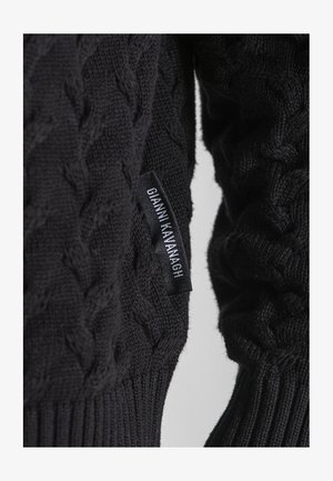 Czarny sweter dzianinowy z wzorem w warkocze, z ribbrowym wykończeniem. Na boku widoczna metka z napisem "GIANNI KAVANAGH".