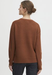 Pull en bronze texturé avec une coupe décontractée, ourlet côtelé et manches longues. La vue arrière révèle un col rond simple.