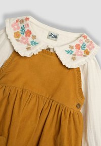Cordkleid in Senfgelb mit einem weißen, gefiederten Kragen und floraler Stickerei. Beinhaltet Knopfdetails und einen gerafften Rockabschnitt.