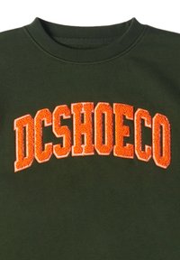 Tmavo zelená mikina s nápisom "DCSHOECO" v tučnom, textúrovanom oranžovom písme naprieč hrudníkom. Klasický dizajn s okrúhlym výstrihom.