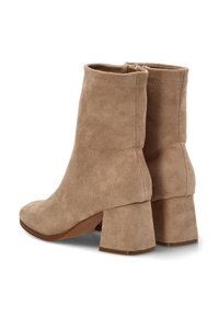 Botas de tobillo de ante beige con punta cuadrada y tacón grueso. Presentan una textura suave y un detalle de costura central en la parte trasera.