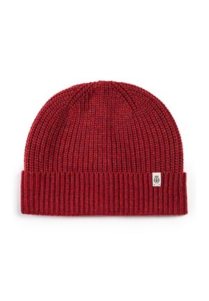 Red knitted beanie with a ribbed texture, featuring a folded cuff and a small tag on the side. Soft fabric is used throughout.