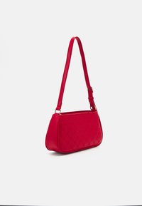 Sac à main en cuir synthétique rouge avec une forme structurée, un motif en relief, une bandoulière réglable et des accents de quincaillerie ton or.