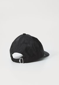 Schwarze Mütze mit einem strukturierten sechseckigen Muster, einem gebogenen Schirm und einem verstellbaren Band auf der Rückseite. Hergestellt aus Stoffmaterial.