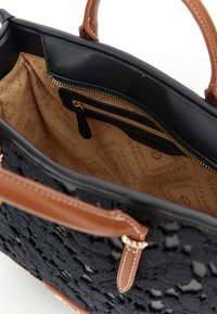 Bolso negro de ganchillo con asas de cuero marrón, bolsillo interior con cremallera y forro de tela beige estampado con el texto "CAFÉNOIR".