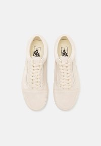 Baskets en daim beige avec un design à lacets, bout rond et semelle en caoutchouc blanche à finition texturée. Marque visible sur la languette.