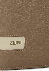Portafoglio in pelle marrone con una superficie testurizzata e un'etichetta rettangolare beige con il nome del marchio "ZWEI" in lettering impresso.