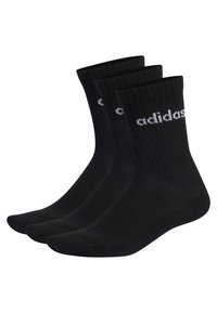 Calcetines de algodón negros con textura acanalada, que presentan el logo blanco de Adidas. Se presentan tres pares, cada uno con un diseño clásico de corte crew.