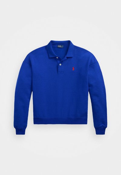 Niebieski długi rękawek polo z kołnierzykiem, z pojedynczym zapięciem na guzik oraz małym czerwonym logo po lewej stronie klatki piersiowej. Materiał z mieszanką bawełny, teksturowane wykończenie.