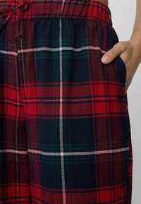 Rode en marineblauwe geruite broek met een elastische tailleband en trekkoord, voorzien van zijzakken en een zachte textuur, geschikt voor casual kleding.