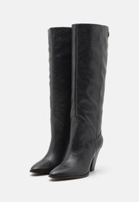 Black ankle boots made of textured leather with a snake print pattern, pointed toe, and a medium heel. Sleek, fitted design.