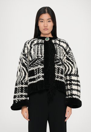 Sort og hvid mønstret cardigan med en tekstureret overflade, rund grøn knaplukning og oversized ærmer. Ribkantede manchetter og nederste kant.