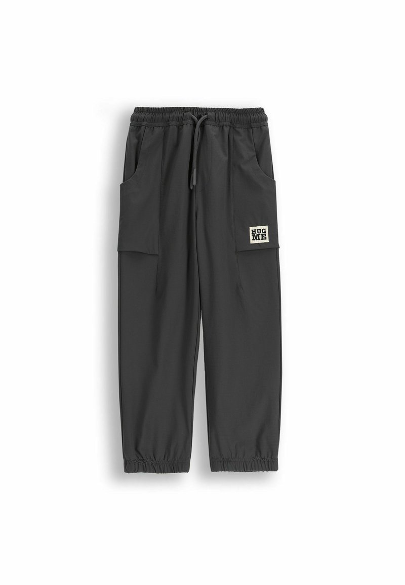 Szare, lekkie spodnie z elastycznym pasem, sznurkiem do regulacji i dwoma bocznymi kieszeniami. Na prawej kieszeni znajduje się naszywka z napisem „HUG ME”.