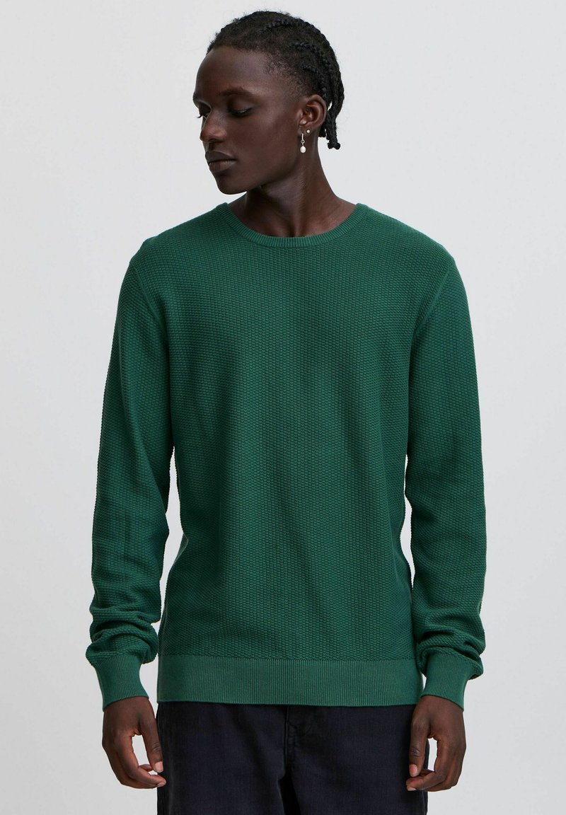 Grüner Strickpullover mit strukturiertem Muster, Rundhalsausschnitt und langen Ärmeln. Gerippte Bündchen und Saum verleihen dem Design Details.