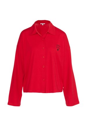 Červená košile s dlouhým rukávem, vyrobená z měkké tkaniny, s límcem a vyšitým logem na prsou, s uvolněným střihem a zakřiveným lemem.