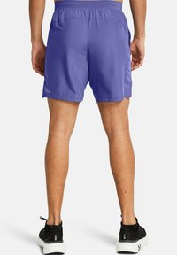 Lila idrottsshorts gjorda av lätt material, med en avslappnad passform, elastisk midja och diskreta sidofickor.