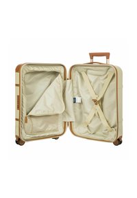 Maleta rígida con acentos marrones, exterior beige e interior marrón claro. Cuenta con dos compartimentos, correas y un bolsillo de malla con cremallera.